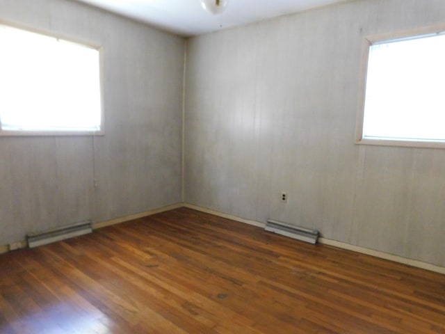 unfurnished room featuring hardwood / wood-style flooring and a baseboard radiator