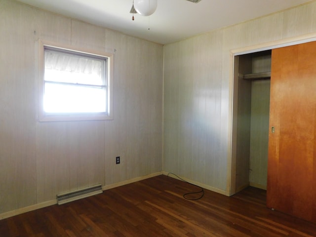 unfurnished bedroom with dark wood-type flooring, a closet, and ceiling fan