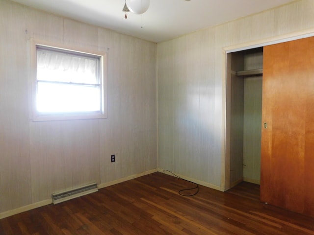 unfurnished bedroom featuring dark hardwood / wood-style flooring, ceiling fan, and a closet