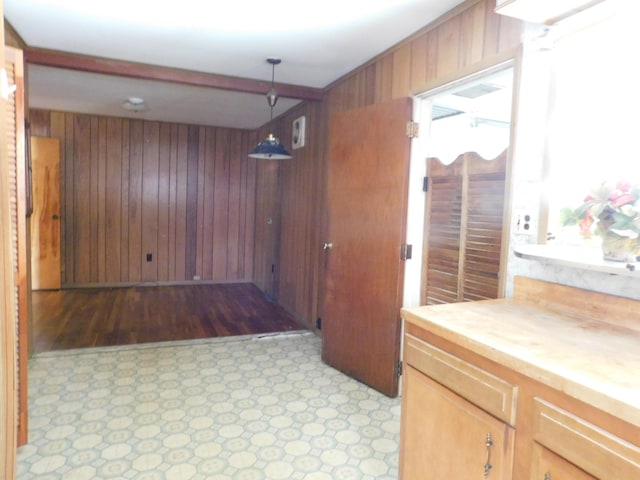 interior space featuring pendant lighting, wood walls, a healthy amount of sunlight, and butcher block countertops