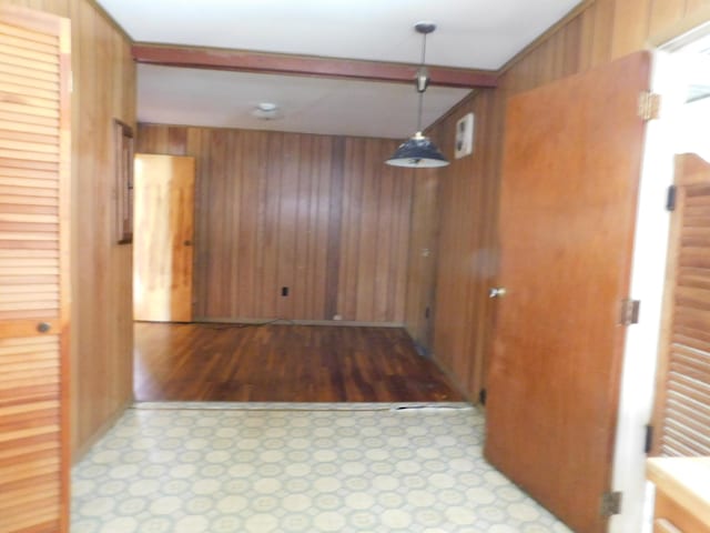 hallway featuring light hardwood / wood-style flooring and wooden walls