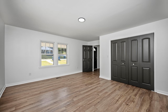 unfurnished bedroom featuring light wood-type flooring and a closet