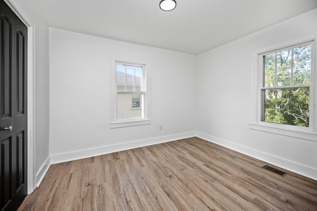 spare room with a healthy amount of sunlight and light hardwood / wood-style flooring