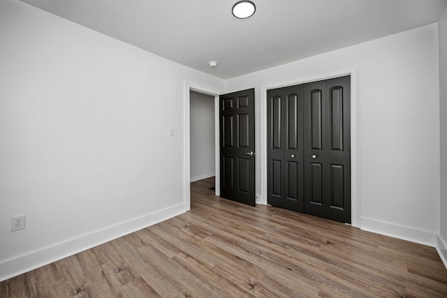 unfurnished bedroom featuring a closet and light hardwood / wood-style floors