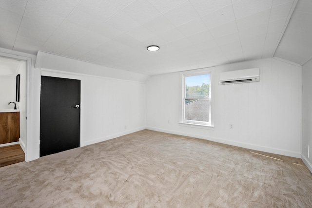 interior space featuring light colored carpet, lofted ceiling, sink, and a wall mounted air conditioner