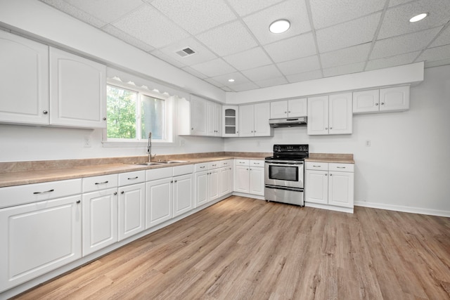 kitchen with a drop ceiling, stainless steel electric range, light hardwood / wood-style flooring, sink, and white cabinets