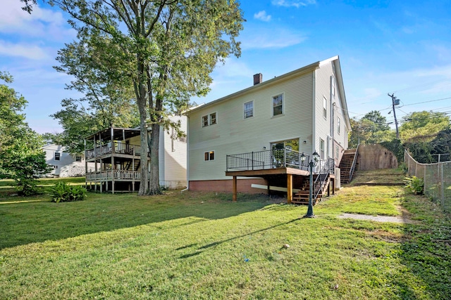 back of property with a yard and a deck