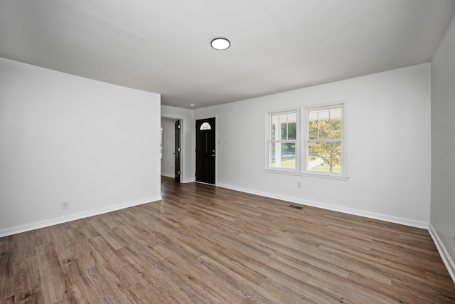 unfurnished room with wood-type flooring