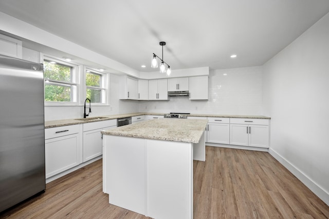 kitchen with a center island, stainless steel appliances, white cabinetry, sink, and pendant lighting