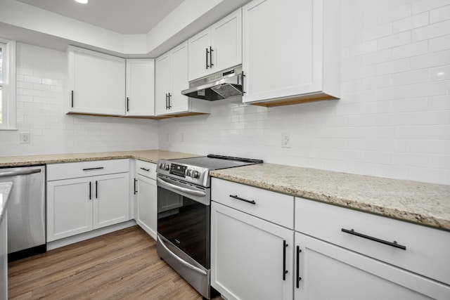 kitchen featuring light wood-type flooring, white cabinets, light stone countertops, and stainless steel appliances