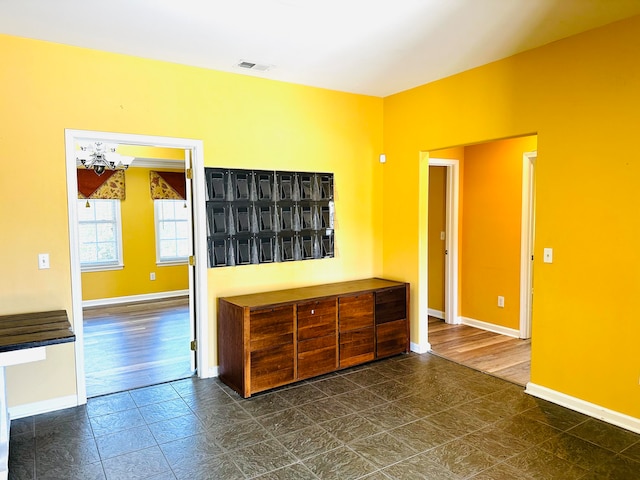 unfurnished room featuring an inviting chandelier