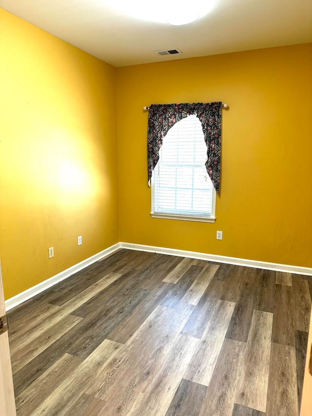 unfurnished room with hardwood / wood-style flooring