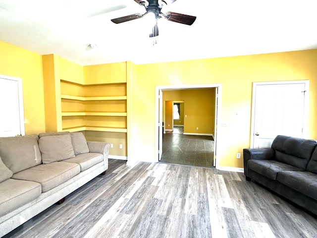 living room featuring ceiling fan and dark hardwood / wood-style flooring