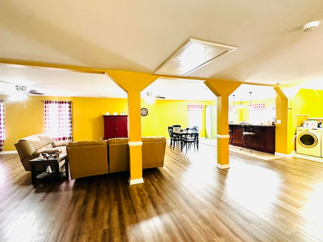 living room with washer / clothes dryer and dark hardwood / wood-style floors