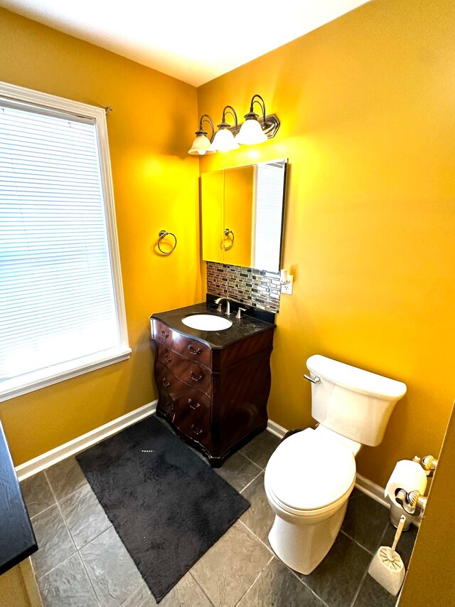 bathroom featuring vanity, toilet, tile patterned flooring, and backsplash