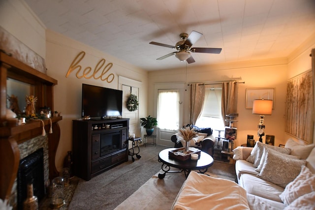 carpeted living area featuring a fireplace and a ceiling fan