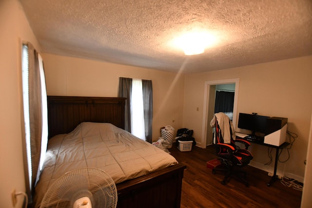 bedroom with a textured ceiling and wood finished floors