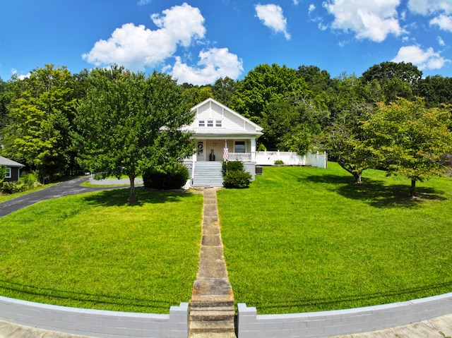 view of front facade featuring a front lawn, fence, and a porch