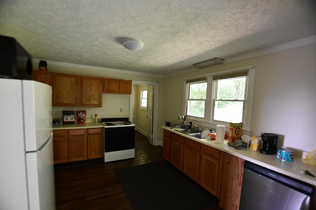 kitchen featuring dark wood-style flooring, a textured ceiling, light countertops, white appliances, and brown cabinetry