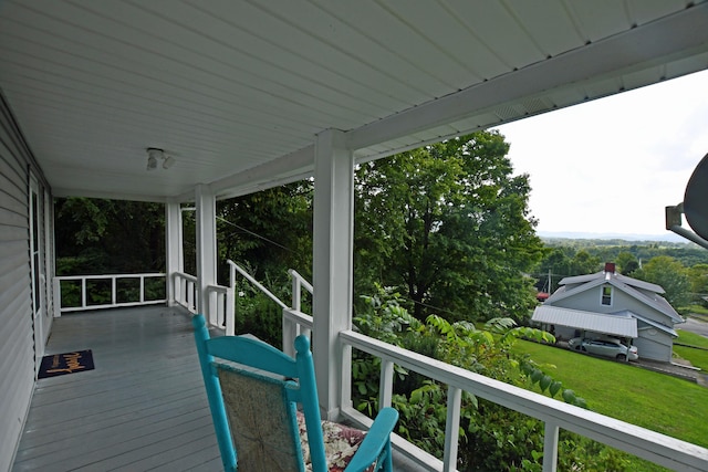 deck featuring a lawn and covered porch
