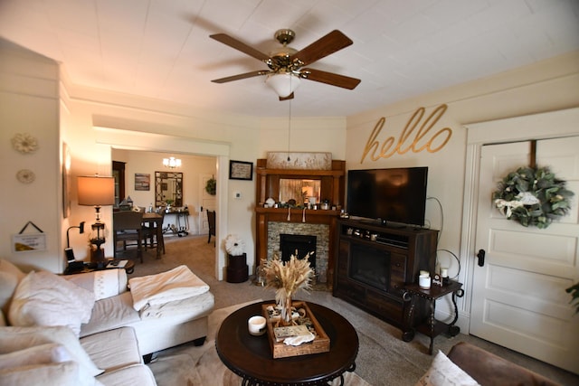 carpeted living room featuring a fireplace and a ceiling fan