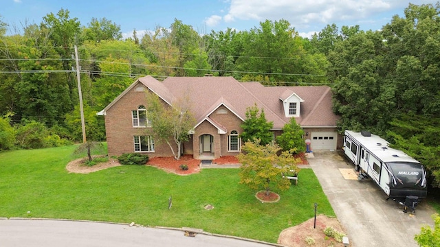 view of front of property featuring driveway, brick siding, and a front yard