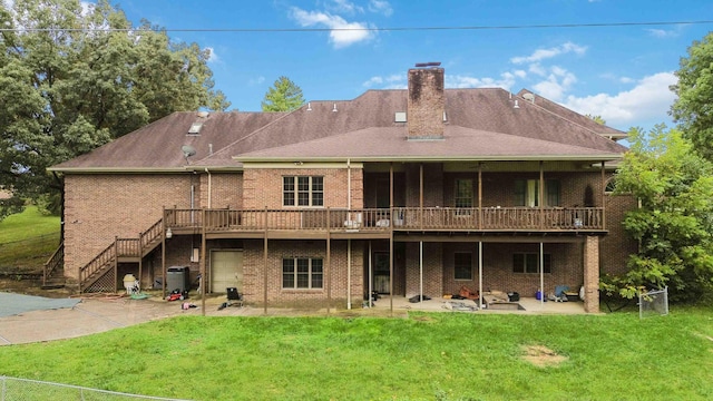 rear view of property with a wooden deck, a lawn, and a patio