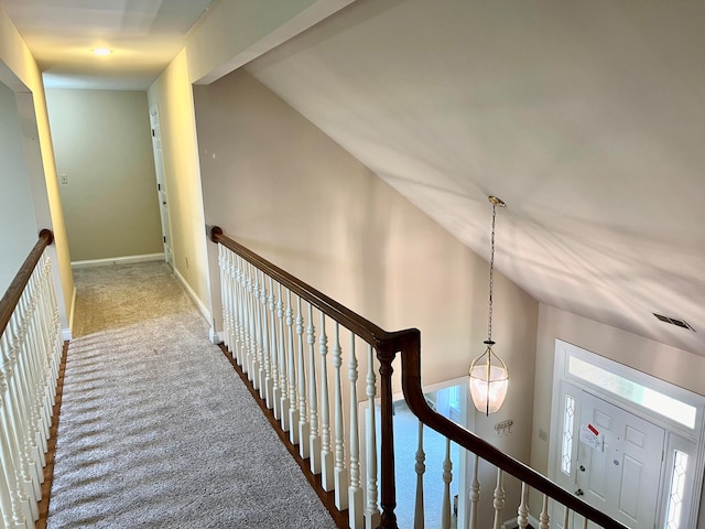 hallway with vaulted ceiling and carpet floors