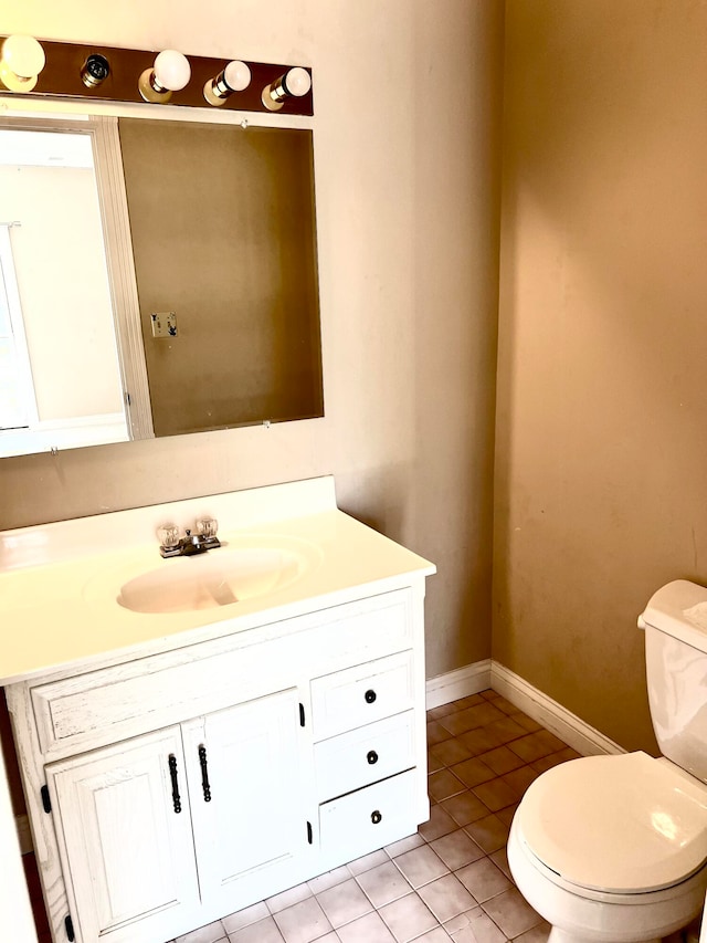 bathroom with tile patterned flooring, vanity, and toilet