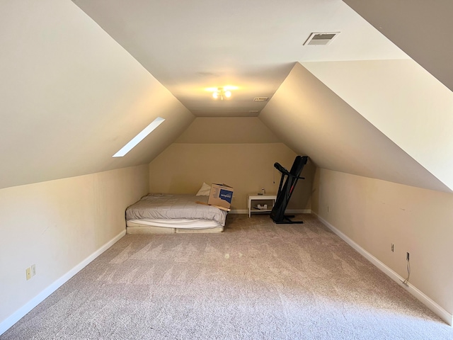 interior space with vaulted ceiling with skylight and carpet