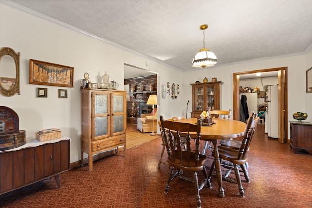 dining area with a textured ceiling, crown molding, and dark hardwood / wood-style floors