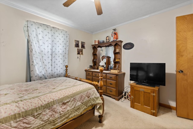 carpeted bedroom with ornamental molding and ceiling fan