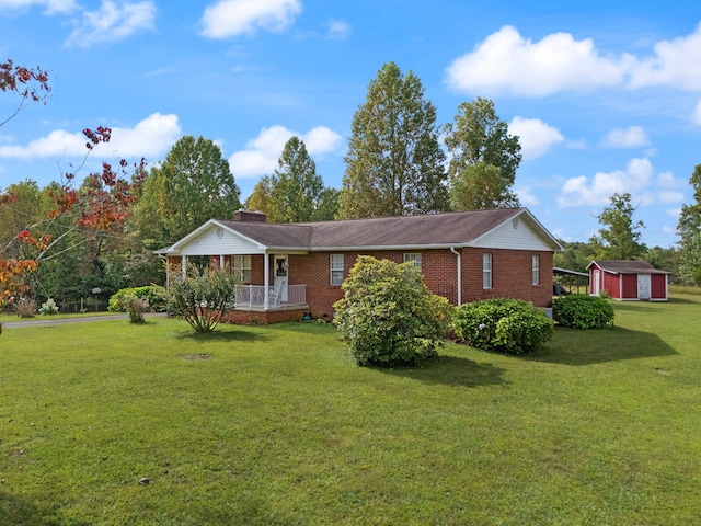 view of front of home featuring a porch, a front yard, and a shed