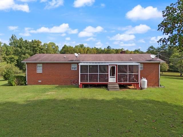 back of house featuring a sunroom and a lawn