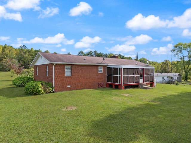 rear view of property featuring a yard and a sunroom