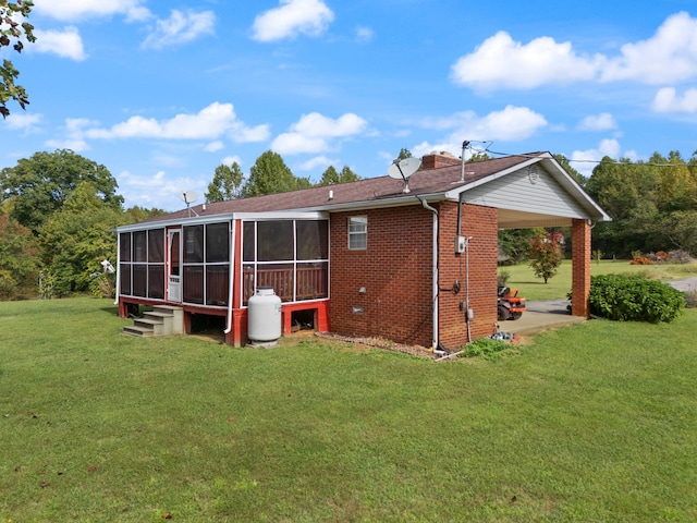 rear view of property with a sunroom and a yard