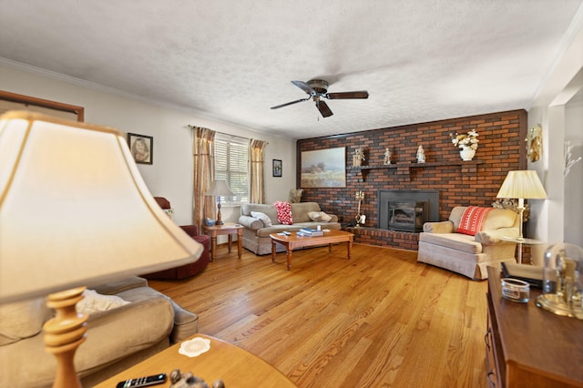 living room featuring ceiling fan, a textured ceiling, hardwood / wood-style floors, and crown molding