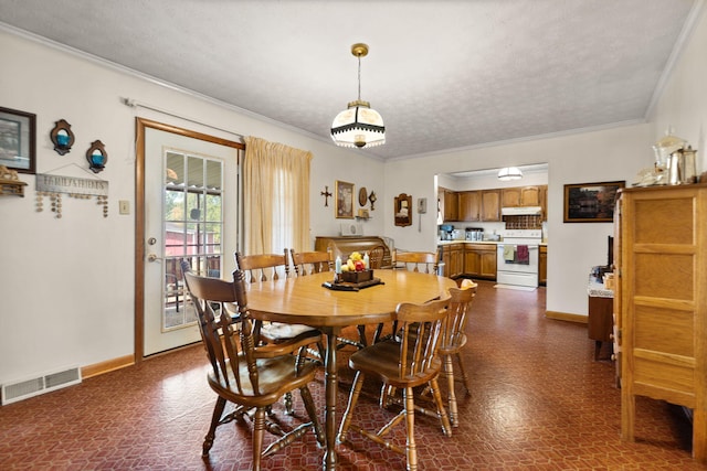 dining space with ornamental molding and a textured ceiling