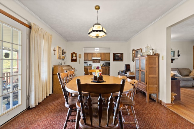 dining space featuring a textured ceiling, crown molding, and dark hardwood / wood-style flooring