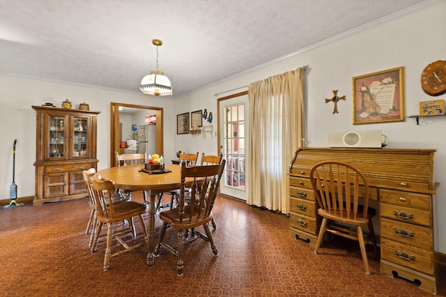 dining space featuring a textured ceiling and ornamental molding