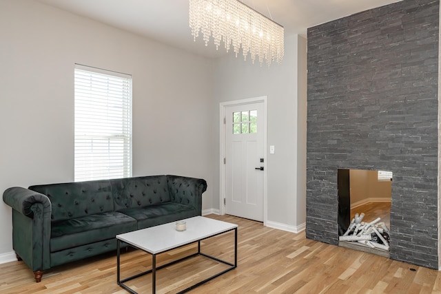 living room featuring a notable chandelier, light wood-type flooring, and baseboards