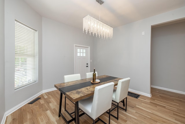 dining area featuring a notable chandelier, visible vents, light wood finished floors, and plenty of natural light