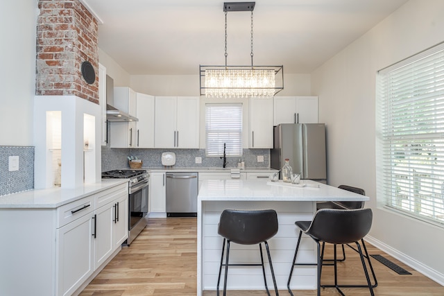 kitchen with visible vents, a breakfast bar area, stainless steel appliances, and decorative backsplash