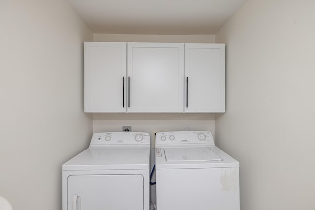 washroom with cabinet space and washing machine and clothes dryer