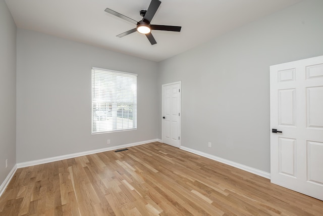 spare room featuring visible vents, baseboards, a ceiling fan, and light wood finished floors