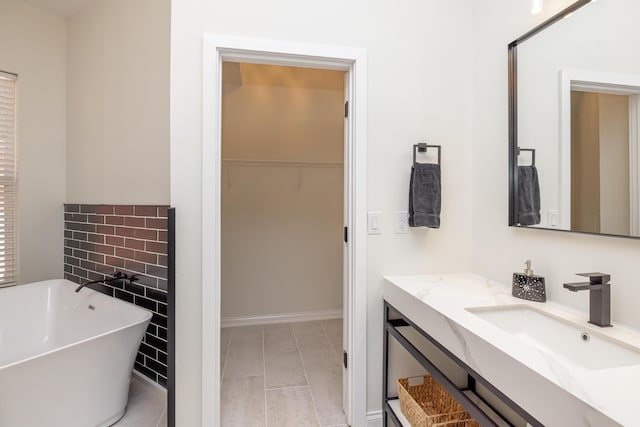 bathroom featuring a walk in closet, a freestanding bath, and vanity