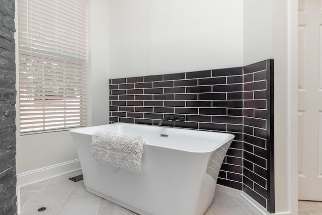 full bathroom with tile patterned floors, visible vents, a freestanding bath, and tile walls