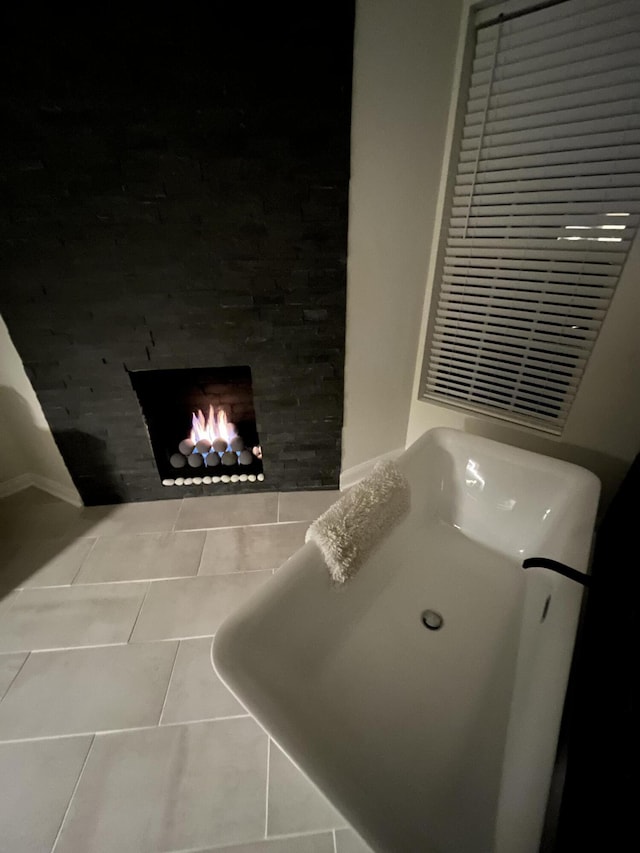 bathroom featuring a lit fireplace and tile patterned flooring