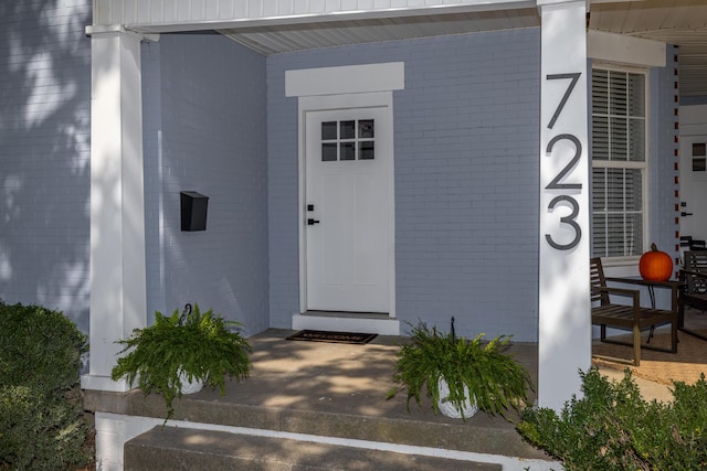 entrance to property featuring brick siding