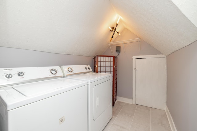 washroom with laundry area, light tile patterned floors, baseboards, a textured ceiling, and washer and dryer